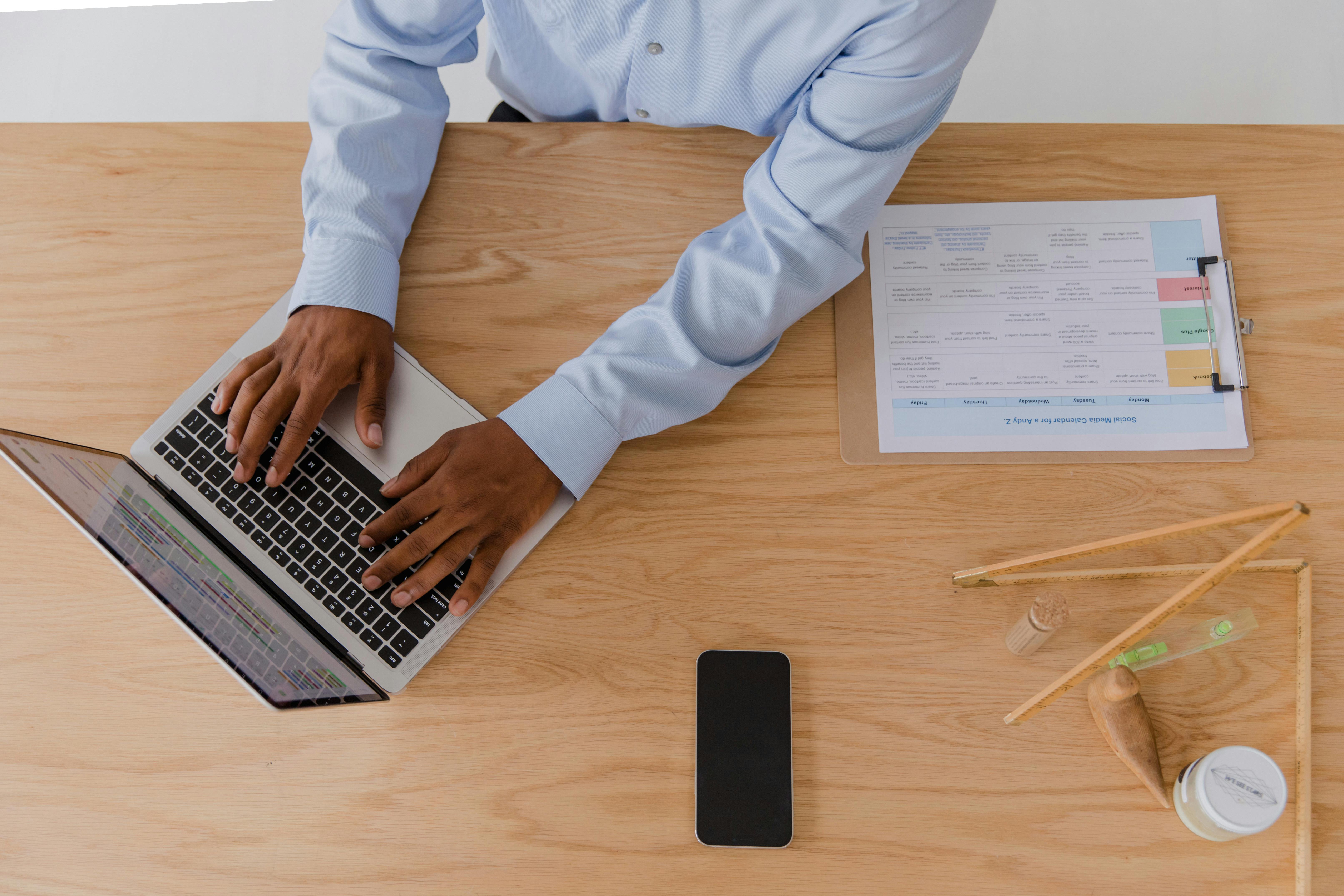 pexels-rdne-10376214 top view of employee working on a laptop with planner and tools for daily task tracking
